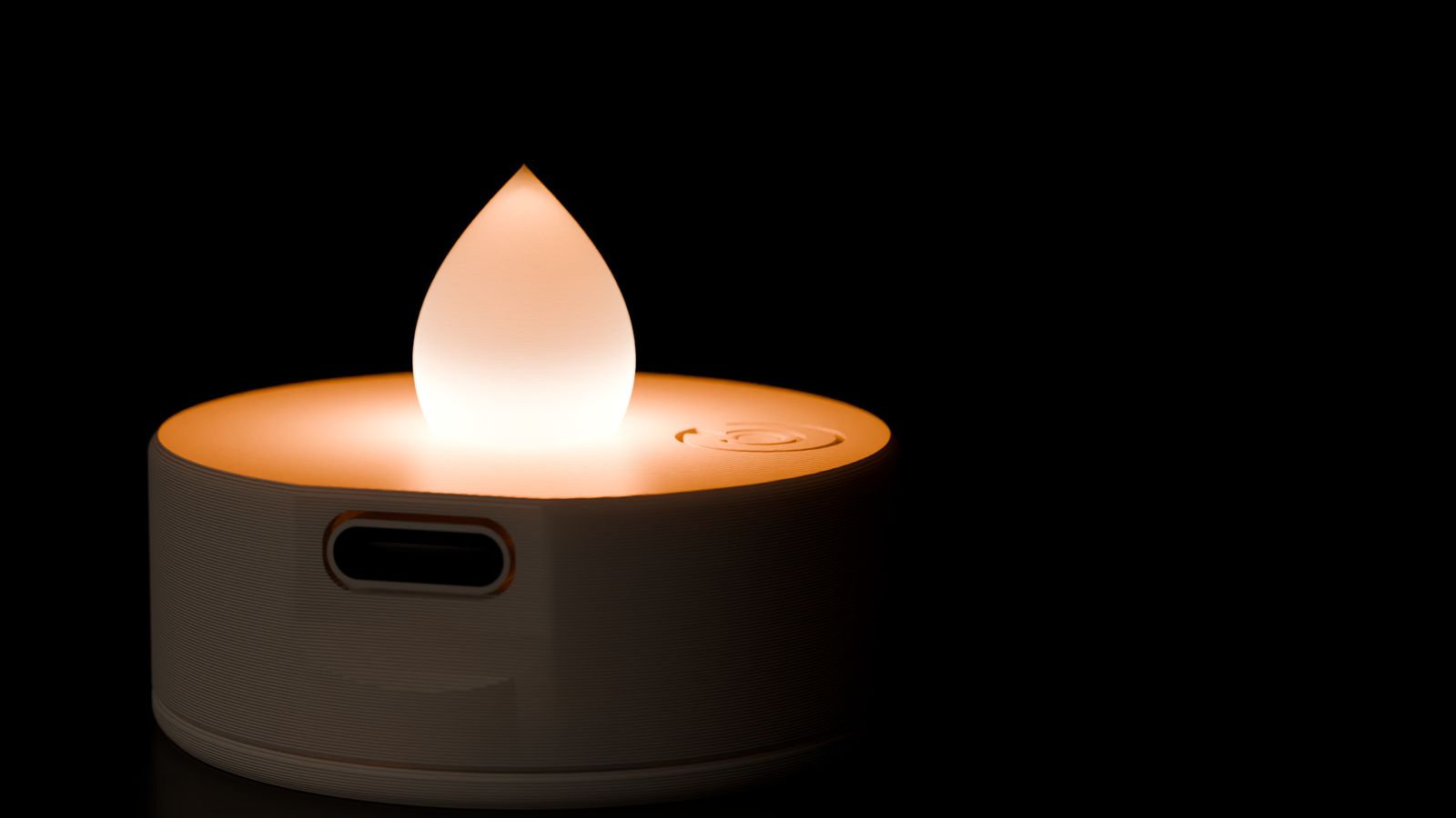 Close-up of the glowing teardrop. The thin print layers show up as rings of light, and the USB-C port is in the side.
